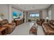 Bright living room featuring tile floors, leather seating, and sliding glass doors to outdoor patio with lake views at 1678 Royal Ct, Punta Gorda, FL 33980