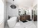 Modern bathroom featuring a soaking tub, dual sink vanity, and stylish lighting fixtures at 1711 Boca Raton Ct, Punta Gorda, FL 33950