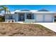 Charming light blue single-story home with a well-manicured lawn and a two-car garage at 1711 Boca Raton Ct, Punta Gorda, FL 33950