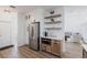 Kitchen with stainless steel refrigerator, wooden floating shelves, and adjoining seating area at 1711 Boca Raton Ct, Punta Gorda, FL 33950