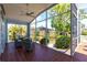 The screened lanai has brick floors, a ceiling fan, and a view to the beautifully landscaped yard at 1711 Boca Raton Ct, Punta Gorda, FL 33950