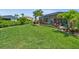 Spacious lawn with lush landscaping and screened-in patio, creating an inviting outdoor living space for relaxation at 17459 Palmetto Pass Ln, Punta Gorda, FL 33982
