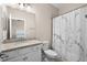 Well-lit bathroom with a granite countertop sink, toilet, and a shower with a decorative curtain at 17459 Palmetto Pass Ln, Punta Gorda, FL 33982