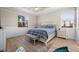 Bright bedroom featuring wood floors, two windows, a ceiling fan, and a white accent wall at 17459 Palmetto Pass Ln, Punta Gorda, FL 33982