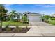 Charming single-story home with well-manicured lawn, lovely landscaping, and a paved driveway leading to a two-car garage at 17459 Palmetto Pass Ln, Punta Gorda, FL 33982