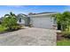 Charming single-story home with well-manicured lawn, lovely landscaping, and a paved driveway leading to a two-car garage at 17459 Palmetto Pass Ln, Punta Gorda, FL 33982