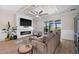 Comfortable living room with a ceiling fan, modern fireplace, TV, and access to the outdoor patio through sliding glass doors at 17459 Palmetto Pass Ln, Punta Gorda, FL 33982