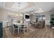 Bright open-plan living and dining area featuring a fireplace, tv, tray ceiling and sliding glass doors to the lanai at 17459 Palmetto Pass Ln, Punta Gorda, FL 33982