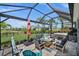 Lush backyard view of the screened patio with a hot tub and cozy seating area, ideal for entertainment at 17459 Palmetto Pass Ln, Punta Gorda, FL 33982