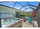 Inviting screened patio with a hot tub, fire pit, dining area, and grill, perfect for outdoor relaxation at 17459 Palmetto Pass Ln, Punta Gorda, FL 33982