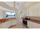 Well-lit kitchen featuring granite countertops, white cabinets, and stainless steel appliances at 1856 Nuremberg Blvd, Punta Gorda, FL 33983