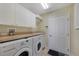 Well-equipped laundry room with washer, dryer, sink, and ample cabinet space at 1856 Nuremberg Blvd, Punta Gorda, FL 33983