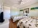 Comfortable bedroom featuring twin beds, ceiling fan, and neutral decor at 19505 Quesada Ave # Ii201, Port Charlotte, FL 33948