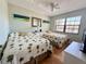 Cozy bedroom with two twin beds, ceiling fan, and bright natural light at 19505 Quesada Ave # Ii201, Port Charlotte, FL 33948
