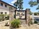 Attractive brick community entrance sign 'Welcome to The Oaks IV' surrounded by lush plants at 19505 Quesada Ave # Ii201, Port Charlotte, FL 33948