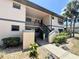 Two-story condo with well-kept landscaping, mature palms, and exterior stairs to the upper level at 19505 Quesada Ave # Ii201, Port Charlotte, FL 33948