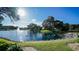 Scenic view of a community lake and lush greenery under a clear blue sky with fountain at 19505 Quesada Ave # Ii201, Port Charlotte, FL 33948