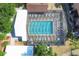 Aerial view of a large screened pool surrounded by lounge chairs, tables, and lush landscaping at 19505 Quesada Ave # Ii201, Port Charlotte, FL 33948