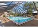 Beautiful screened community pool with plenty of lounge chairs and tables for relaxation at 19505 Quesada Ave # Ii201, Port Charlotte, FL 33948
