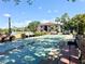 Community shuffleboard and benches surrounded by lush landscaping and a scenic lake view with fountain at 19505 Quesada Ave # Ii201, Port Charlotte, FL 33948