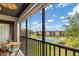 Relaxing balcony view overlooking lush greenery, tennis courts and community buildings on a clear, sunny day at 1999 Kings Hwy # 24C, Punta Gorda, FL 33980