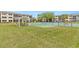 A grassy picnic area with a pavilion, a BBQ grill, shuffleboard, and tennis courts, with green scenery all around at 1999 Kings Hwy # 24C, Punta Gorda, FL 33980
