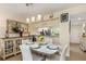 Cozy dining area with modern lighting, white table set for four, and open access to the kitchen at 1999 Kings Hwy # 24C, Punta Gorda, FL 33980