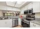 Bright kitchen showcases stainless steel appliances and granite countertops, open to the living area at 1999 Kings Hwy # 24C, Punta Gorda, FL 33980