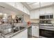 Kitchen showcasing stainless steel appliances, granite countertops, and pass-through to the living room at 1999 Kings Hwy # 24C, Punta Gorda, FL 33980