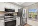 Modern kitchen featuring stainless steel appliances and white cabinets with view to outside at 1999 Kings Hwy # 24C, Punta Gorda, FL 33980