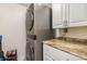 Laundry room with stacked washer and dryer and white cabinets with decorative hardware at 1999 Kings Hwy # 24C, Punta Gorda, FL 33980