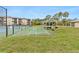 Exterior view of community shuffleboard courts and tennis courts with complex buildings in the background at 1999 Kings Hwy # 24C, Punta Gorda, FL 33980