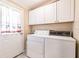 Bright laundry room features white cabinets and a window-clad door at 200 Summerset Dr, Punta Gorda, FL 33982