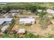 Aerial view of the rear of the home with large yard, wooded surroundings, and a relaxing porch at 200 Summerset Dr, Punta Gorda, FL 33982