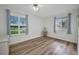 Bright bedroom featuring wood-look floors, a ceiling fan, and two windows offering plenty of natural light at 20355 Mount Prospect Ave, Port Charlotte, FL 33952