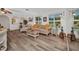 Inviting living room featuring light wood flooring, arched doorways, natural lighting, and comfortable, neutral-toned furniture at 20355 Mount Prospect Ave, Port Charlotte, FL 33952