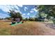 Spacious backyard featuring an outdoor seating area, pond, fire pit, and lush trees at 20407 Albury Dr, Port Charlotte, FL 33952