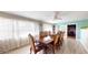 Dining room features a large wood table set, fan, and bright natural light from the large windows at 20407 Albury Dr, Port Charlotte, FL 33952