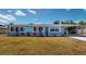 Charming single-story home with a blue door, stone accents, and a well-manicured lawn at 20407 Albury Dr, Port Charlotte, FL 33952