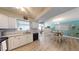 Well-lit kitchen with white cabinetry and a view into the adjacent dining area at 20407 Albury Dr, Port Charlotte, FL 33952
