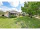 Lush backyard with green grass, mature trees, and lake views at 2087 Lynx Run, North Port, FL 34288