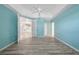 Bedroom with light-blue walls, white ceiling fan, and wood-look floors at 2087 Lynx Run, North Port, FL 34288