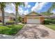 Charming home featuring a two-car garage, tiled roof, lush landscaping, and a welcoming brick driveway at 2087 Lynx Run, North Port, FL 34288