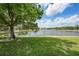 Scenic view of a lake with grass and trees at 2087 Lynx Run, North Port, FL 34288