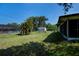 Lush backyard featuring a storage shed, a screened-in pool area, and mature trees creating a private outdoor space at 2113 Barksdale St, Port Charlotte, FL 33948