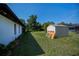Spacious backyard with a storage shed, lush lawn, and mature trees for a private outdoor retreat at 2113 Barksdale St, Port Charlotte, FL 33948