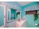 Vibrant bathroom with colorful blue walls, framed mirror, and a single sink at 2113 Barksdale St, Port Charlotte, FL 33948