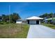 A single-story home featuring a covered carport and well-maintained front lawn on a sunny day at 2113 Barksdale St, Port Charlotte, FL 33948