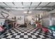 Spacious garage featuring checkered floors, ample storage cabinets, and a Corvette emblem on the wall at 2113 Barksdale St, Port Charlotte, FL 33948