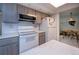Bright kitchen area with gray cabinets, white appliances, and a view into the adjacent dining area at 2113 Barksdale St, Port Charlotte, FL 33948